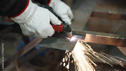 Shimmering sparks and flame in the process of metal cutting, professional welder in protective gloves working with different types and sizes of metal in workshop, process of cutting steel with oxy