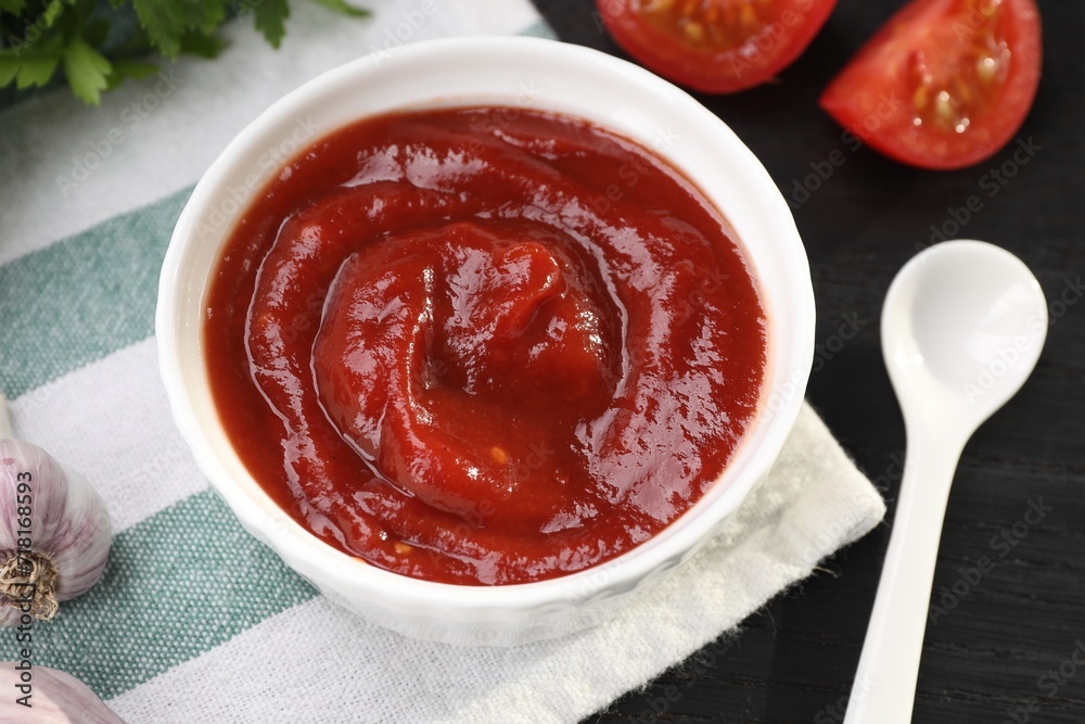 Organic ketchup in bowl on black table, closeup. Tomato sauce Organic ketchup in bowl on black table, closeup. Tomato sauce