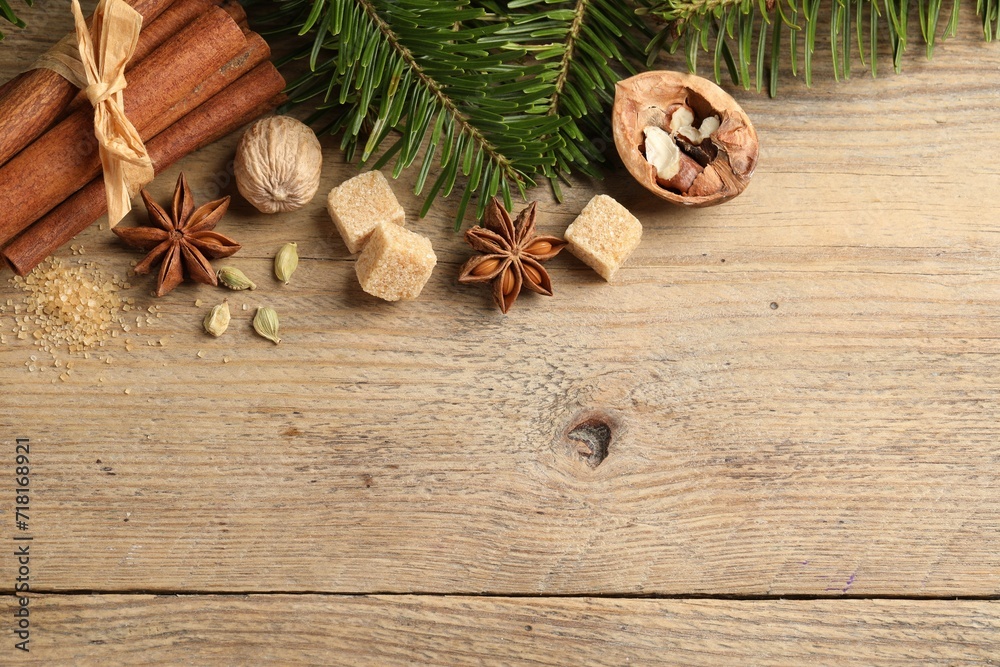 Different aromatic spices and fir branches on wooden table, flat lay. Space for text Different aromatic spices and fir branches on wooden table, flat lay. Space for text