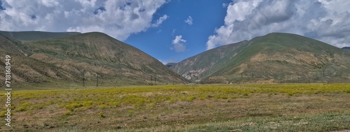  serene beauty of the Armenian countryside, showcasing rolling hills adorned with lush greenery and vibrant wildflowers. Traditional stone houses dot the landscape, reflecting the rich cultural herita photo