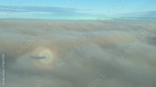 A circulair halo, glory or Brocken spectre around an airplane above the clouds in the sun photo