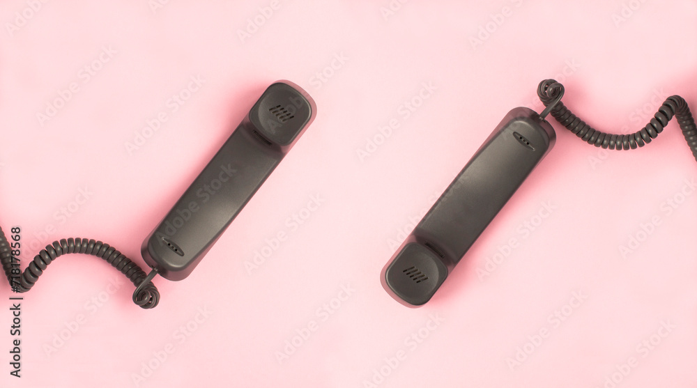 Gray telephone receiver on the pink background. Top view. Copy space. Close-up.