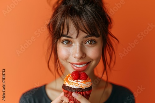 Beautiful women holding small cake on orange  peach fuzz background
