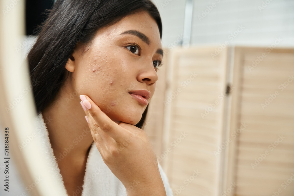 Φωτογραφία young asian woman with brunette hair and blemish on face looking at mirror in ba