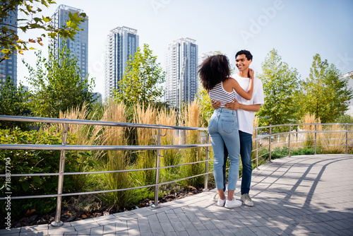 Photo of positive adorable wife husband wear casual clothes embracing walking river embankment outside urban city street © deagreez