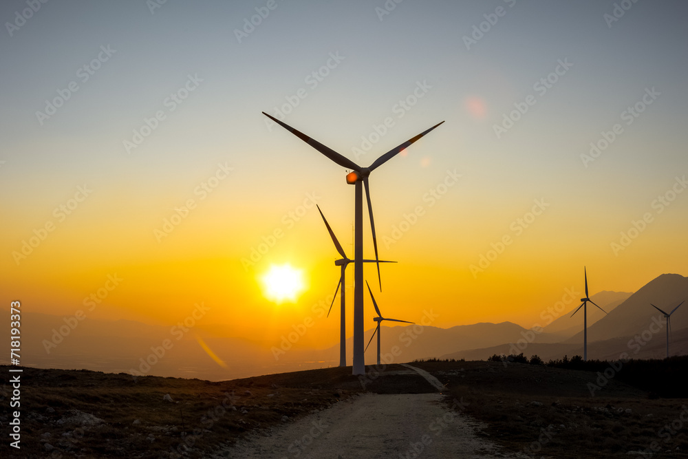 A wind farm or wind park at sunset located in the mountains of Italy Europe and it allows to realize clean energy. It’s sustainable, renewable energy for enviromental