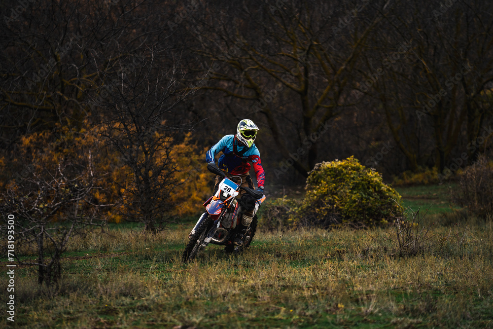 Professional motorcyclist in full moto equipment riding crops enduro ...