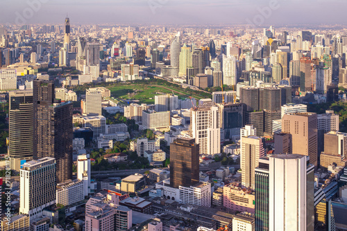 An expansive aerial shot captures a densely populated city's towering skyscrapers and urban layout in soft light..