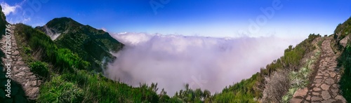 Hiking activity in Madeira island rocky mountains. Trail for Pico Ruivo highest point passing in the clouds.