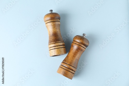 Wooden salt and pepper shakers on light background, top view photo