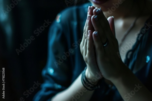 A dark background provides the backdrop as female hands are clasped in prayer, offering ample copy space generative ai © Gilang