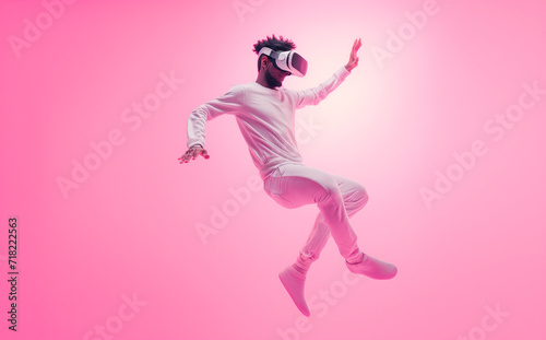 Fashionable young adult in a full white ensemble captured in a dynamic pose while wearing a VR headset against a pink background