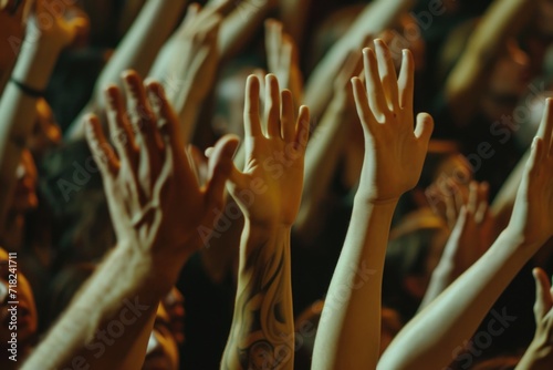 A lively crowd of people raising their hands in the air. Perfect for capturing the energy and enthusiasm of a concert, sporting event, or celebration.