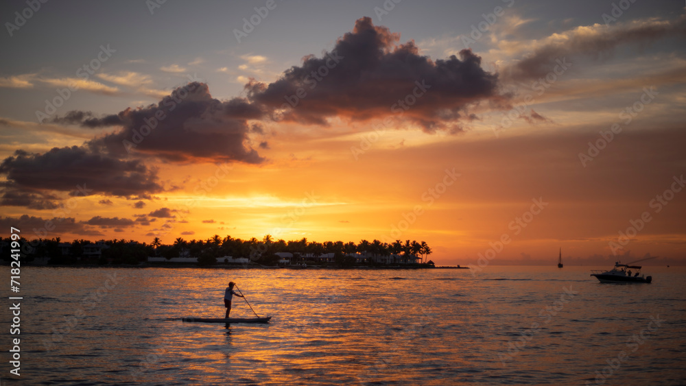 man on a paddle at sunset