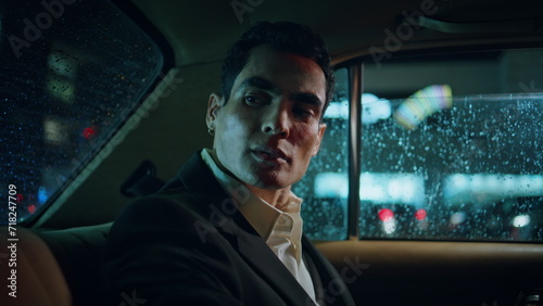 Strict businessman looking car window back rainy night. Serious man sitting taxi © stockbusters