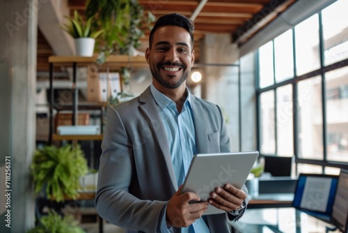 Cheerful Latin Executive Balances His Responsibilities With Tablet At Work. Сoncept Successful Entrepreneurial Mindset, Effective Time Management, Multitasking Skills, Professional Work Environment