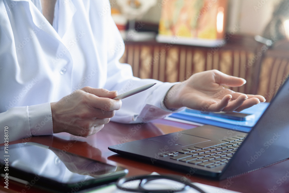 Doctor working with laptop computer and mobile phone in office. Doctor working with laptop computer and mobile phone in office.