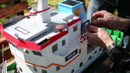 The man fastens a lifeboat on ship model near Big Putyaevsky Pond photo