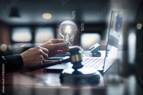 Lawyer at work with a laptop and a light bulb on a wooden desk. photo