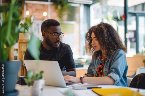 Young entrepreneurs or student discussing and planning next to a laptop. 