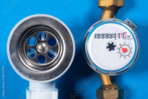 Siphon metal water drain hole and water meter close up top view flat lay background. photo