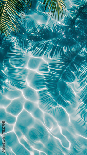 Aesthetic background of clear blue water with reflections and shadows of palm leaves. Tropical vacation vibe © AnnTokma