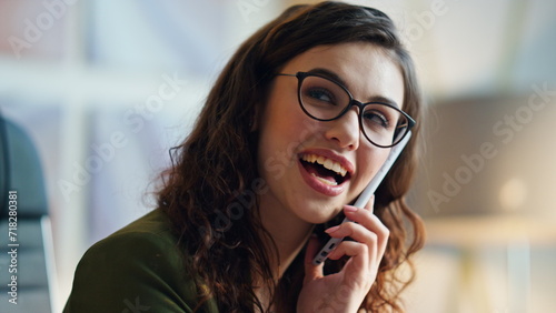 Closeup woman talking phone with smile indoors. Cheerful girl speaking telephone
