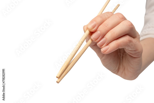 Female hand holding wooden sushi chopsticks isolated on white background.