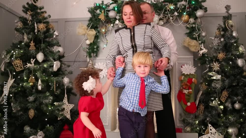Mother, father, son and daughter pose near christmas trees Mother, father, son and daughter pose near christmas trees