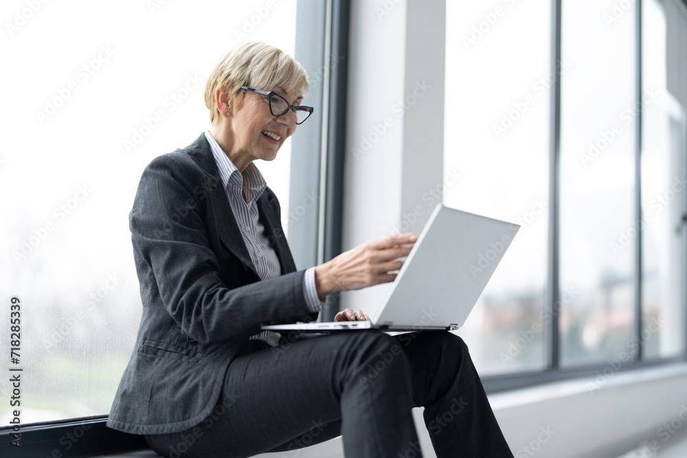 Middle aged blonde business woman using laptop Middle aged blonde business woman using laptop