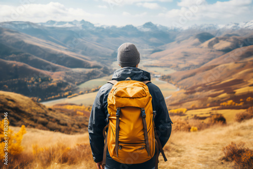 Hiker, tourist, person with yellow backpack. Autumn nature in mountains, panoramic landscape, traveler relax holiday concept, trip vacation, travel adventure. 