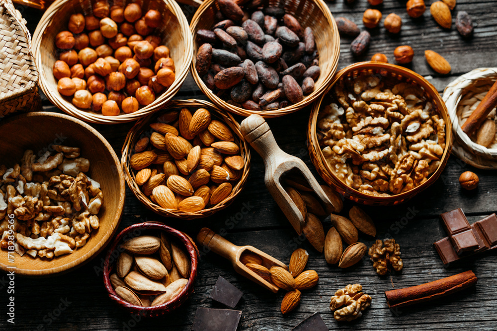 Handmade wicker baskets and wood plates with almonds, hazelnut, walnut. Vintage food background with different nuts and baskets. Handmade wicker baskets and wood plates with almonds, hazelnut, walnut. Vintage food background with different nuts and baskets.