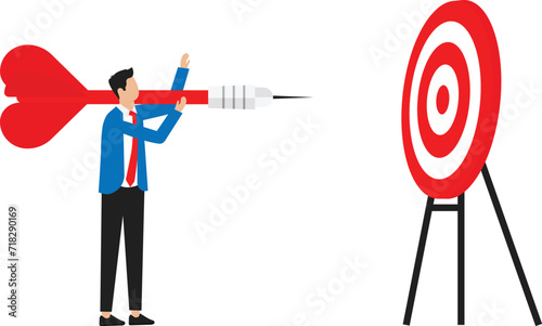 Focus on business goal and reaching target or achievement, achieve business objective or purpose, motivation to success concept, businessman holding dart jumping right to dartboard bullseye.
