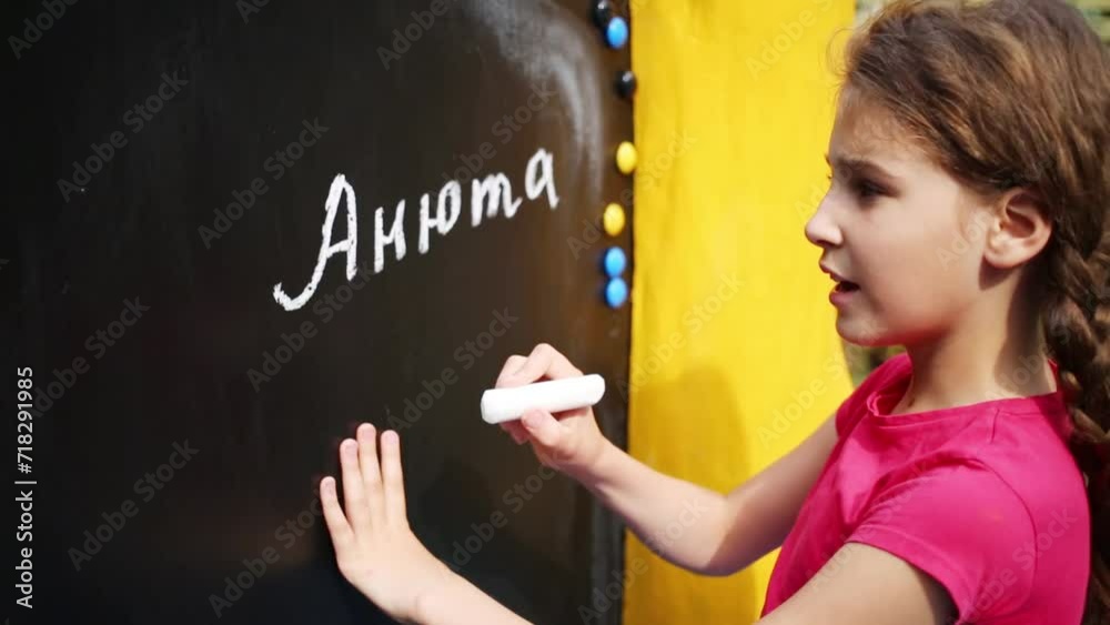 Girl written on blackboard in chalking her name Annie