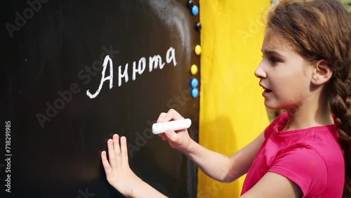 Girl written on blackboard in chalking her name Annie photo