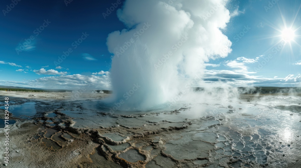  a geyser spewing water into the air with a bright blue sky in the background and a few clouds in the sky overcast blue sky above.