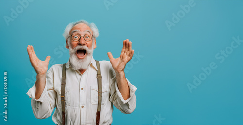 Old hoary man wearing glasses over isolated blue background. Crazy and scared with hands on head, afraid and surprised of shock with open mouth Closeup photo of excited crazy attractive grandpa  photo