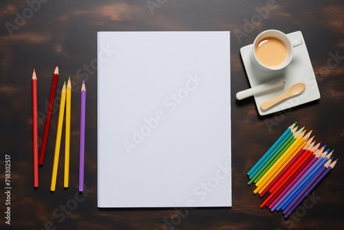 empty white paper mockup and colorful crayons on the brown table with coffee with milk  flat lay. Artistic workplace template. Arts and crafts. photo