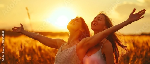 Backlit Portrait of calm happy smiling two free women with open arms and closed eyes enjoys a beautiful moment life on the fields at sunset	
 photo