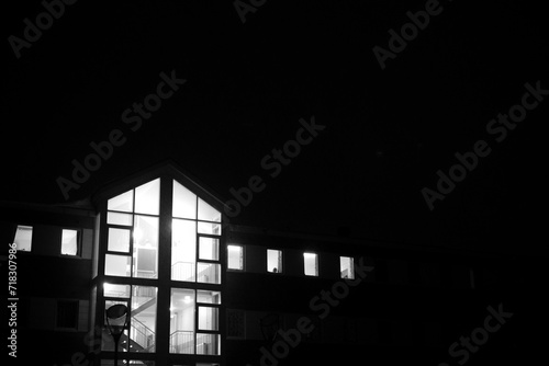 Black And White photo of a lit building, during the night.