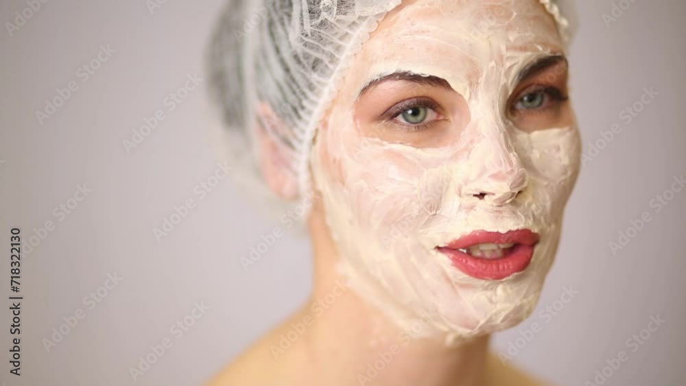 Close up of face of smiling woman in mask of cream in beauty salon. Close up of face of smiling woman in mask of cream in beauty salon.