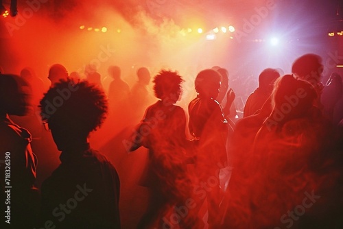 Silhouettes of people dancing at a music festival, lights and smoke. Crowd of people dancing at concert
