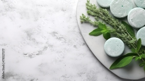 a white plate topped with green leaves next to a white plate of powdered donuts on a marble surface.
