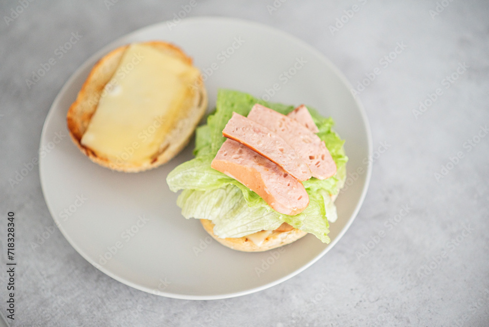 Delicious healthy sandwich for a snack breakfast in men's hands. Toast bread tomato ham leaf salad