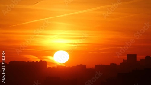 Silhouettes of houses of a modern city during sunrise. Time lapse.