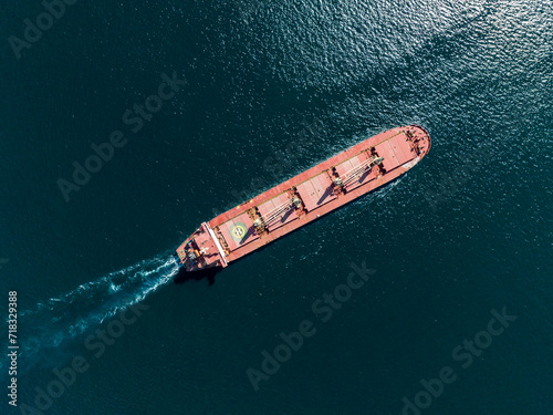 Aerial top view of cargo maritime ship with contrail in the ocean ship carrying container and running for export concept technology freight shipping by ship forwarder mast © FATIR29