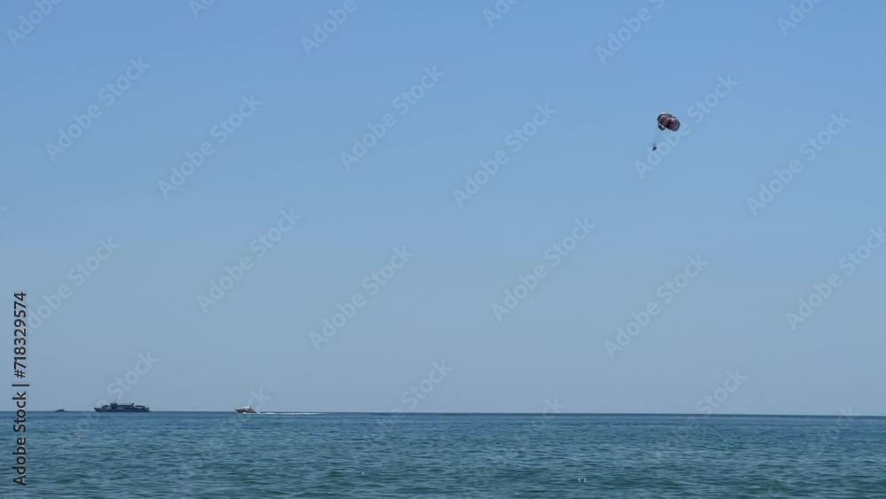 Parasailing: a boat with a marine parachute on the waves. The concept of a cloudy landscape, freedom and summer. Parachutists over the surface of the Black Sea against the sky on a summer day. 4K Parasailing: a boat with a marine parachute on the waves. The concept of a cloudy landscape, freedom and summer. Parachutists over the surface of the Black Sea against the sky on a summer day. 4K