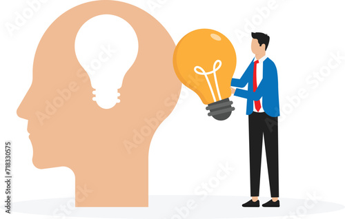 Business man in a suit holding a light bulb on top head human chang idea concept
