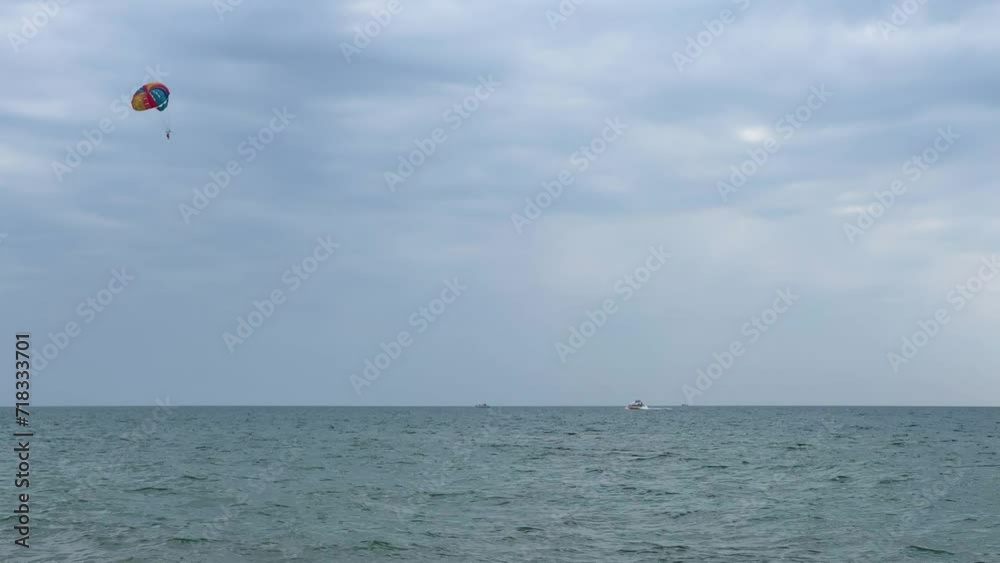 Parasailing: a boat with a marine parachute on the waves. The concept of a cloudy landscape, freedom and summer. Parachutists over the surface of the Black Sea against the sky on a summer day. 4K Parasailing: a boat with a marine parachute on the waves. The concept of a cloudy landscape, freedom and summer. Parachutists over the surface of the Black Sea against the sky on a summer day. 4K