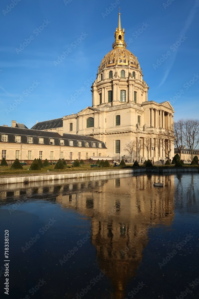 Dôme des Invalides, célèbre monument à Paris, se reflétant dans l’eau gelée d’une fontaine dans un jardin (France)